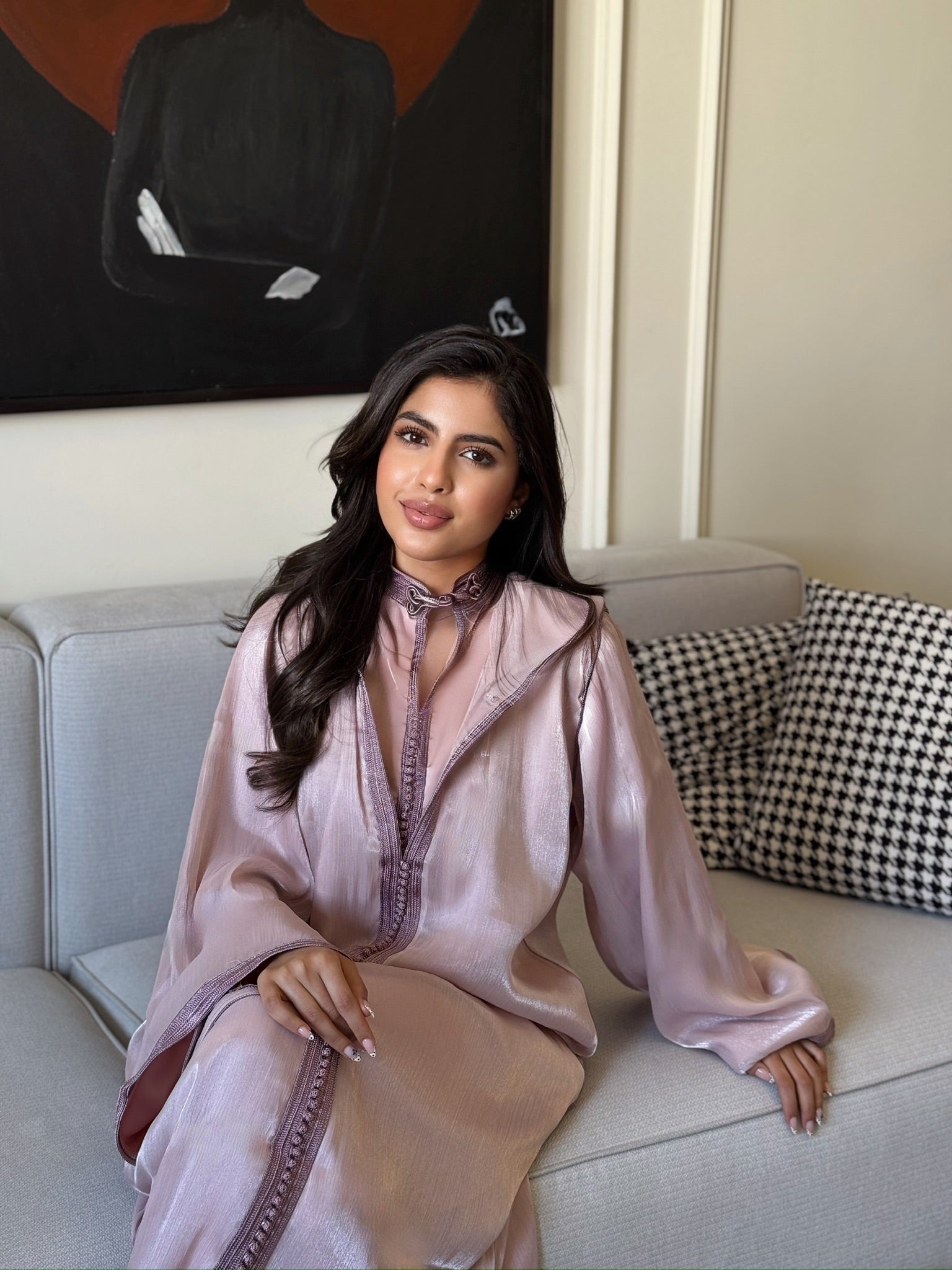 Woman wearing a blush pink jellaba with flowing sleeves and elegant silhouette