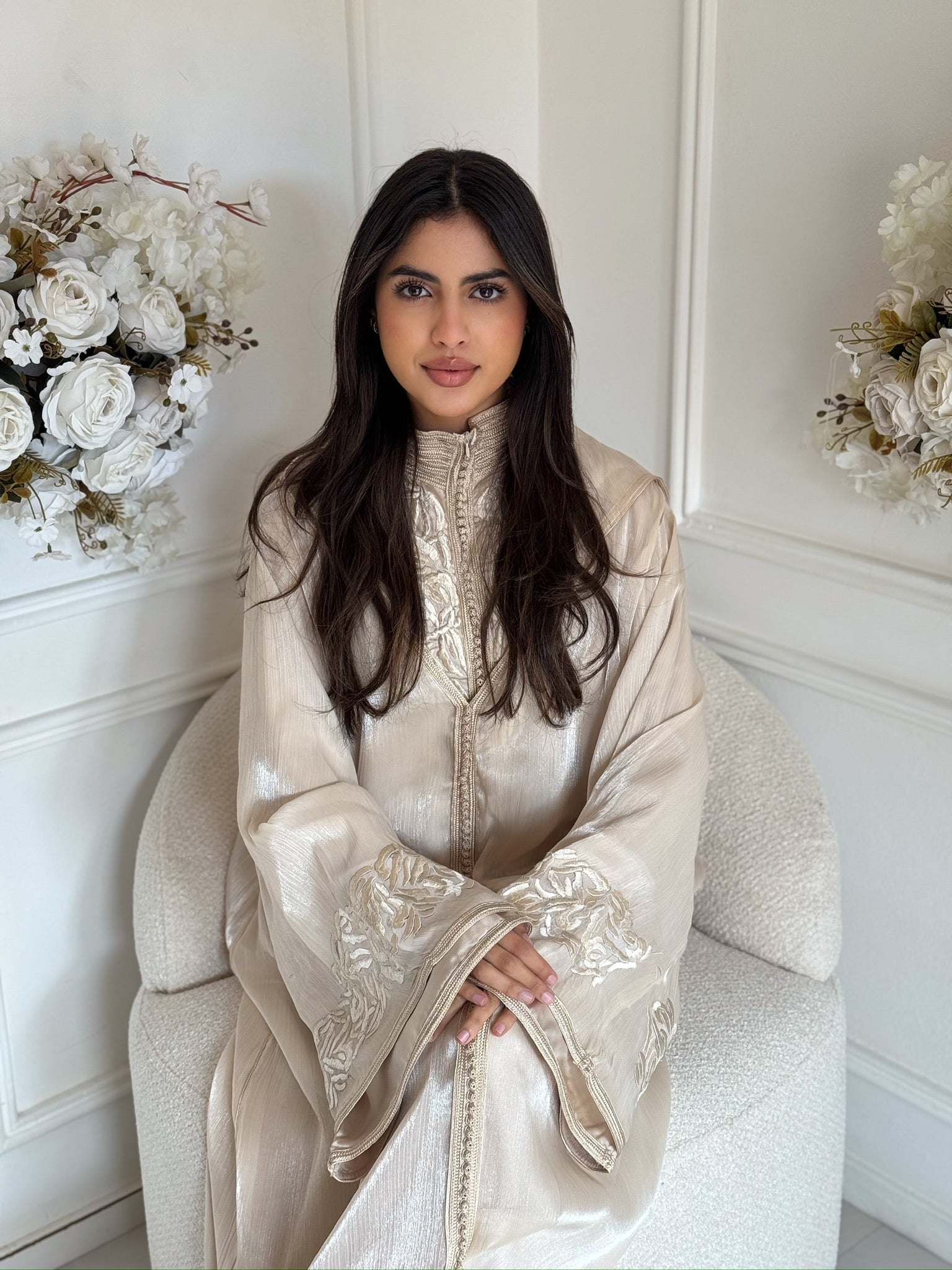 Woman wearing elegant cream Moroccan jellaba with flowing sleeves