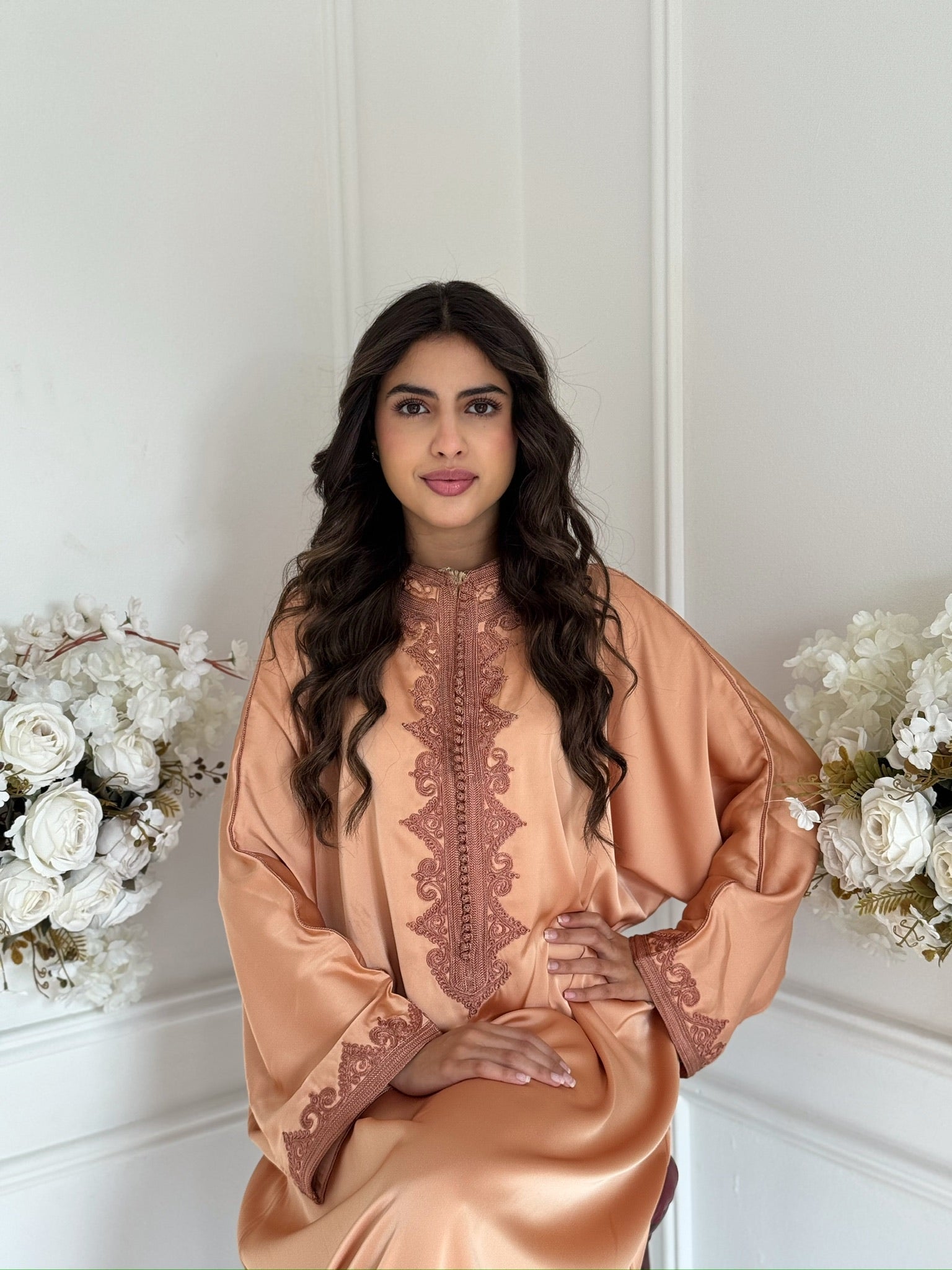Model wearing the Takchita Ranya Moroccan dress in peach drap de soie fabric.
