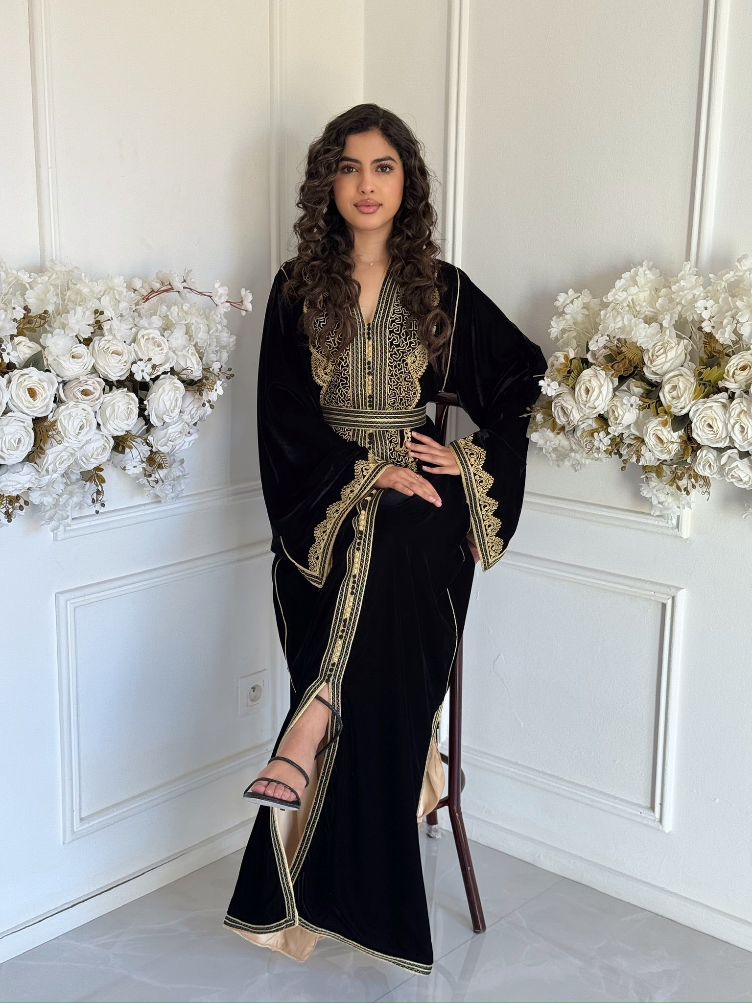 Full view of the black and gold Caftan Celine by Mobra shown in a refined setting.