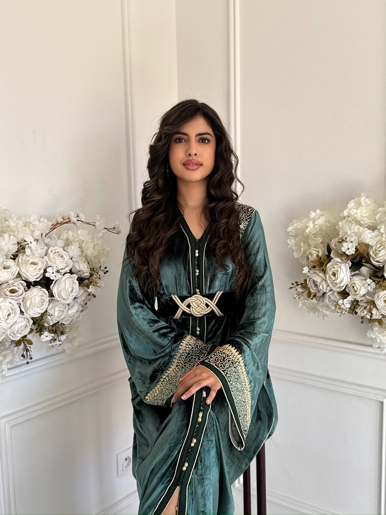 Model wearing Caftan Chaymae – emerald green velvet Moroccan caftan with gold embroidery